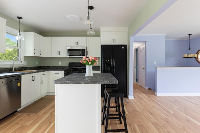 82 Stirrup Cir, Williston, VT 05495 - kitchen with black appliances, a sink, dark countertops, light wood-type flooring, and ornamental molding