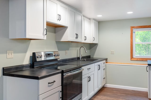 82 Stirrup Cir, Williston, VT 05495 - kitchen featuring stainless steel range with electric stovetop, a sink, dark wood-style floors, dark countertops, and white cabinets
