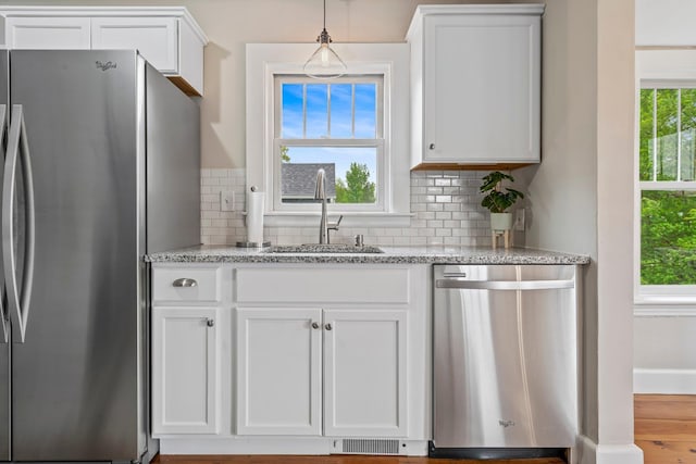 546 Salmon Falls Rd, Rochester, NH 03868 - kitchen featuring stainless steel appliances, a sink, white cabinetry, and light stone countertops