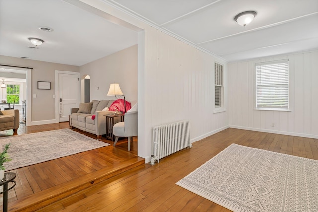 546 Salmon Falls Rd, Rochester, NH 03868 - living area featuring radiator, hardwood / wood-style flooring, arched walkways, and baseboards