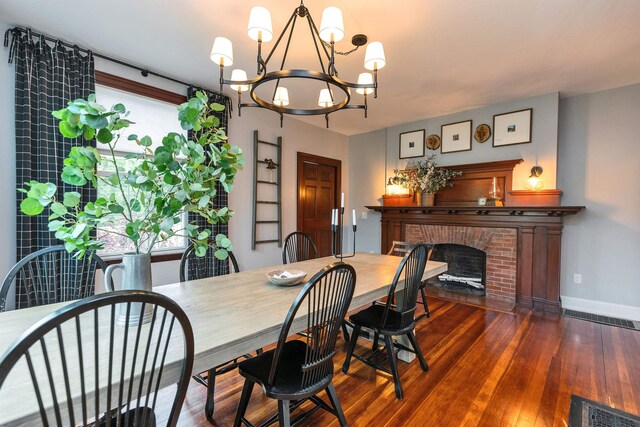 120 S Mast St, Goffstown, NH 03045 - dining area featuring a chandelier, hardwood / wood-style flooring, baseboards, and a brick fireplace