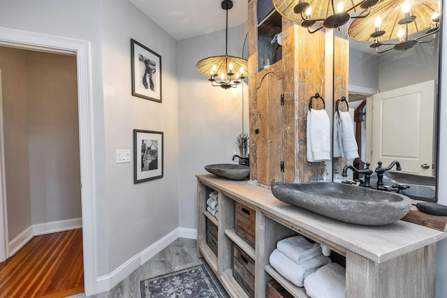 120 S Mast St, Goffstown, NH 03045 - bathroom featuring a chandelier, wood finished floors, double vanity, and baseboards