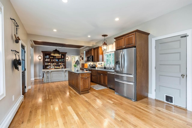 120 S Mast St, Goffstown, NH 03045 - kitchen featuring appliances with stainless steel finishes, baseboard heating, a kitchen island, light wood-type flooring, and a sink