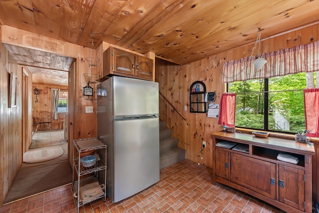 50 Browns Beach Rd, Bristol, NH 03222 - kitchen with freestanding refrigerator, wooden walls, brick patterned floors, wooden ceiling, and hanging light fixtures