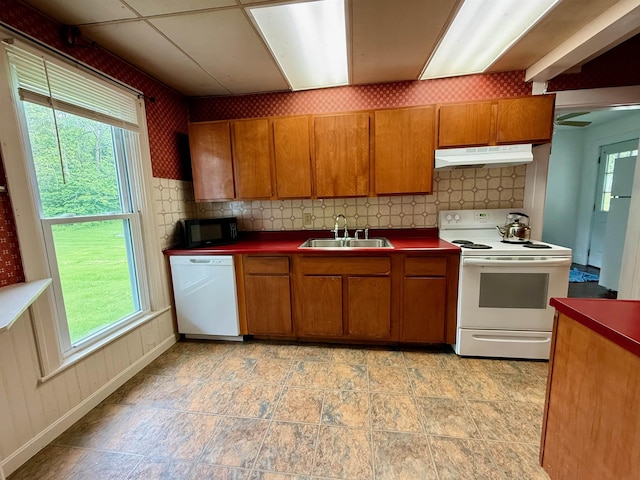 927 Water St, Bennington, VT 05257 - kitchen with white appliances, a sink, under cabinet range hood, brown cabinetry, and plenty of natural light