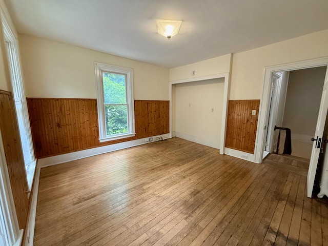 927 Water St, Bennington, VT 05257 - unfurnished bedroom featuring wainscoting, wood-type flooring, wood walls, and a closet