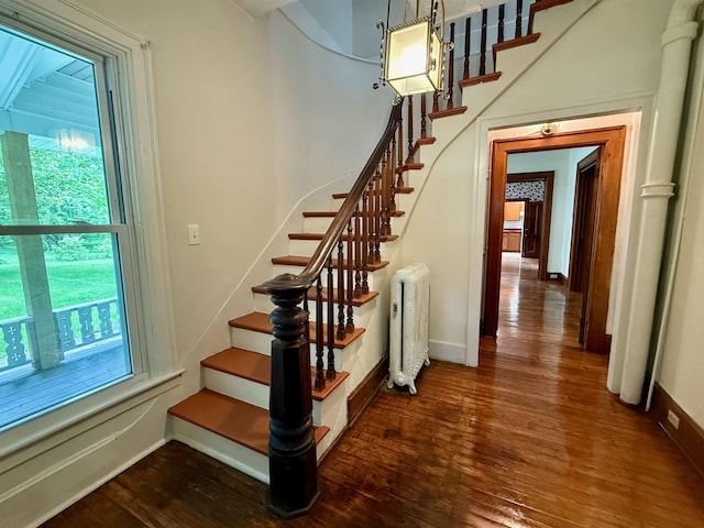 927 Water St, Bennington, VT 05257 - staircase featuring radiator, plenty of natural light, wood-type flooring, and baseboards