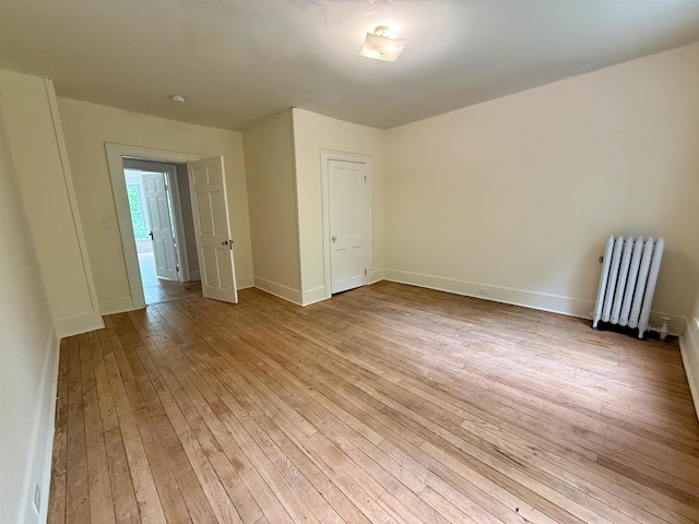 927 Water St, Bennington, VT 05257 - empty room featuring radiator heating unit, light wood-style floors, and baseboards
