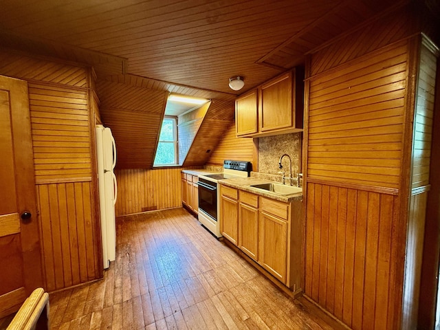 927 Water St, Bennington, VT 05257 - kitchen with range with electric stovetop, a sink, freestanding refrigerator, wood walls, and light wood-type flooring
