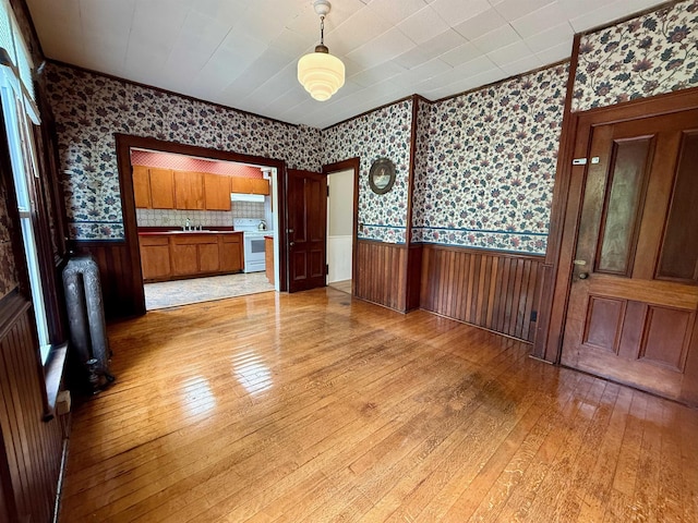 927 Water St, Bennington, VT 05257 - unfurnished dining area featuring wallpapered walls, a wainscoted wall, light wood finished floors, and a sink