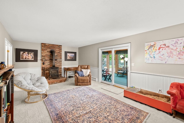 55 Honey Hill Rd, Hinesburg, VT 05461 - carpeted living room with a wood stove, wainscoting, and baseboard heating