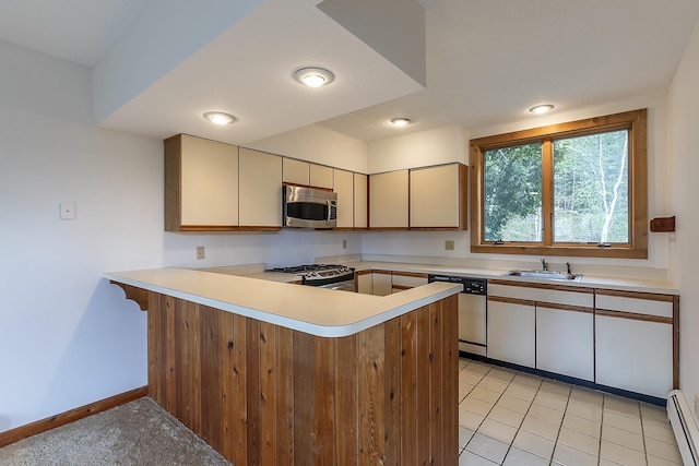 46 Willows Way Unit 5, Peru, VT 05152 - kitchen with stainless steel appliances, a peninsula, light countertops, a sink, and baseboard heating