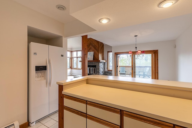 46 Willows Way Unit 5, Peru, VT 05152 - kitchen featuring white refrigerator with ice dispenser, baseboard heating, light countertops, pendant lighting, and a glass covered fireplace
