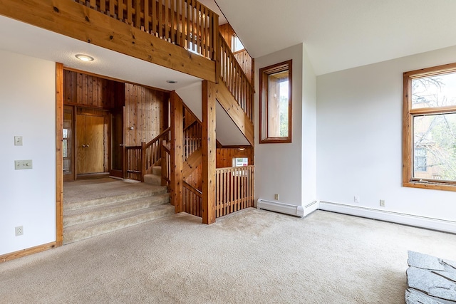 46 Willows Way Unit 5, Peru, VT 05152 - unfurnished living room featuring carpet flooring, stairs, wooden walls, and baseboards