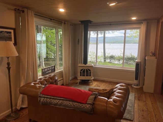 87 Chase Point Rd, Tuftonboro, NH 03853 - living area with a wood stove, baseboards, wood-type flooring, a water view, and recessed lighting