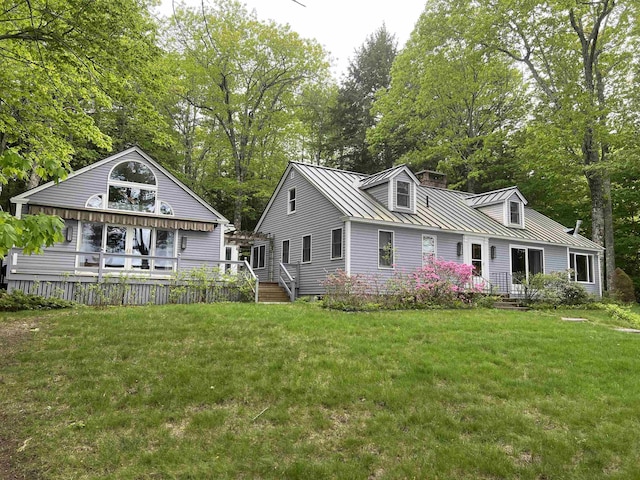 87 Chase Point Rd, Tuftonboro, NH 03853 - view of front of house with a standing seam roof, metal roof, a front yard, and view of wooded area