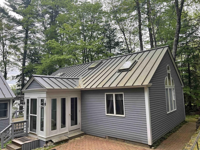 87 Chase Point Rd, Tuftonboro, NH 03853 - rear view of house featuring a standing seam roof, metal roof, and a patio