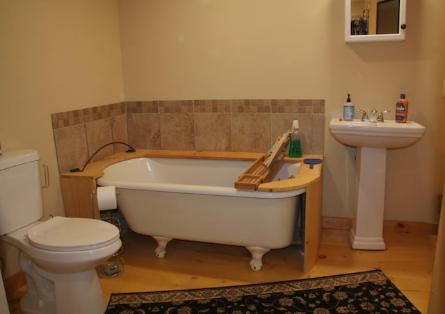 1083 Back Center Rd, Lyndon, VT 05851 - bathroom featuring wood finished floors, a soaking tub, toilet, and a sink
