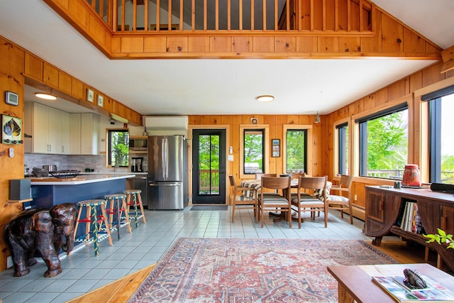 304 Green Bay Loop, Peacham, VT 05862 - living room featuring healthy amount of natural light, wooden walls, and light tile patterned floors