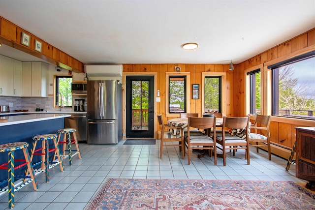 304 Green Bay Loop, Peacham, VT 05862 - dining space featuring light tile patterned flooring, plenty of natural light, and wood walls