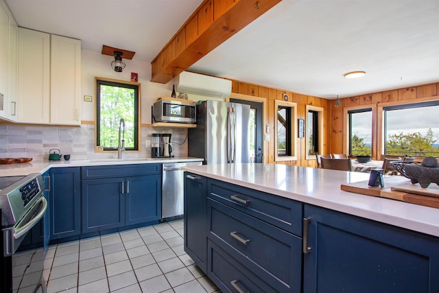 304 Green Bay Loop, Peacham, VT 05862 - kitchen with stainless steel appliances, blue cabinetry, a sink, light countertops, and decorative backsplash