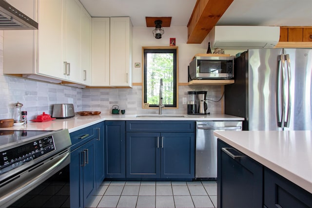 304 Green Bay Loop, Peacham, VT 05862 - kitchen featuring appliances with stainless steel finishes, under cabinet range hood, blue cabinets, a sink, and light tile patterned floors