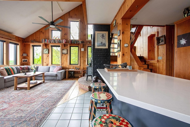 304 Green Bay Loop, Peacham, VT 05862 - living room with wood walls, tile patterned floors, ceiling fan, and high vaulted ceiling