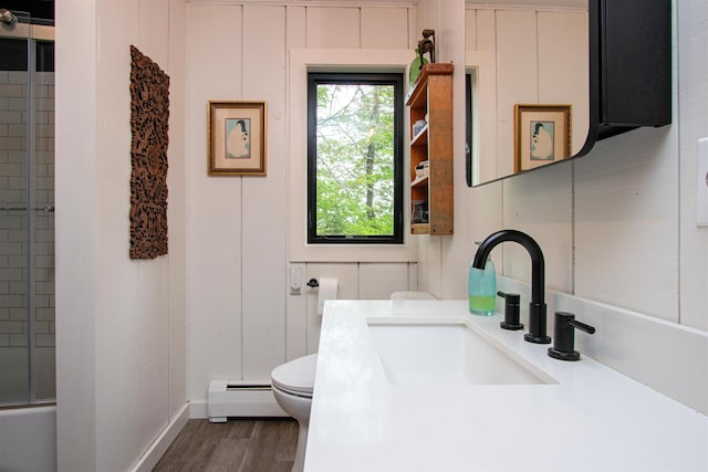 304 Green Bay Loop, Peacham, VT 05862 - full bath with a baseboard heating unit, toilet, a shower with shower door, vanity, and wood finished floors