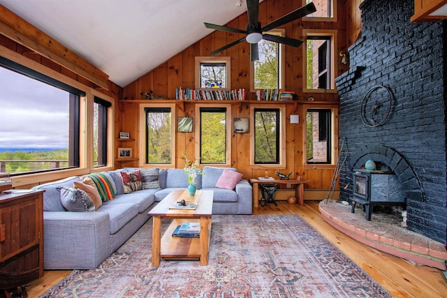 304 Green Bay Loop, Peacham, VT 05862 - living area with plenty of natural light, a wood stove, wood walls, hardwood / wood-style flooring, and ceiling fan