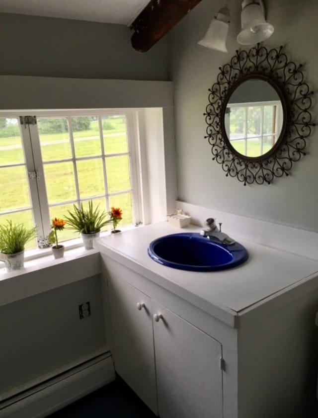 1186 Pucker St Unit 1.5Acres, Stowe, VT 05672 - bathroom with baseboard heating, vanity, and plenty of natural light
