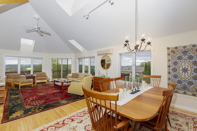 24 N Peak Vlg, Newbury, NH 03255 - dining space with a skylight, a wall mounted air conditioner, wood finished floors, high vaulted ceiling, and a chandelier
