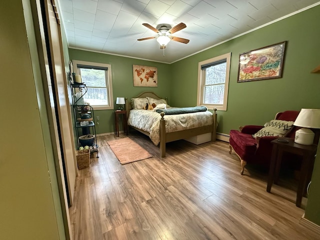 261 Vt 15 E Rd, Hyde Park, VT 05655 - bedroom with ornamental molding, multiple windows, baseboard heating, light wood finished floors, and a ceiling fan