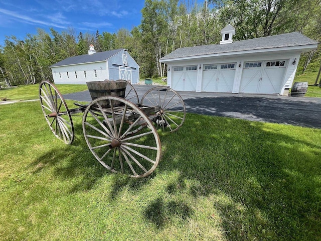 959 Presidential Hwy, Jefferson, NH 03583 - view of green lawn featuring a garage, view of wooded area, and an outbuilding