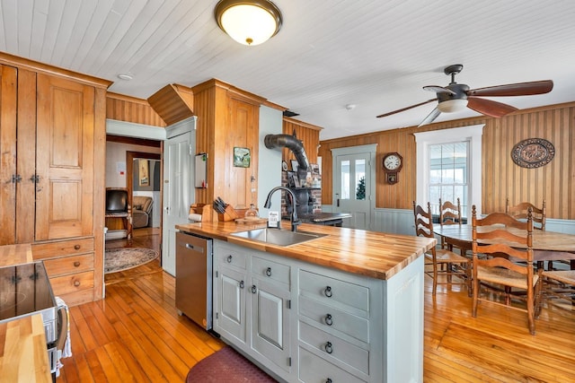 959 Presidential Hwy, Jefferson, NH 03583 - kitchen featuring dishwasher, a wood stove, a sink, butcher block countertops, and light wood-style floors