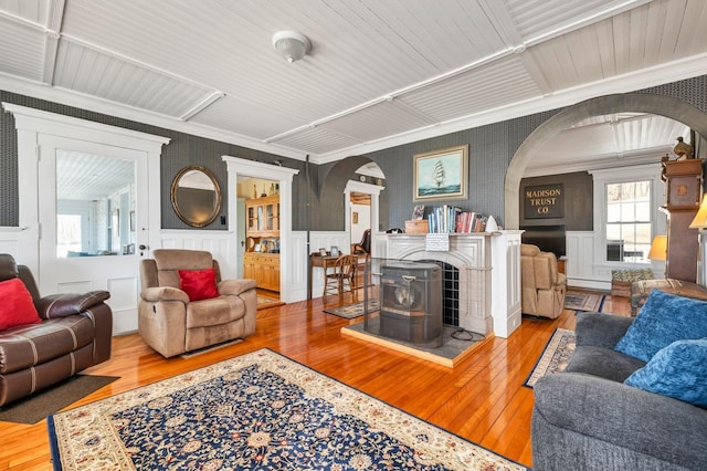 959 Presidential Hwy, Jefferson, NH 03583 - living area with arched walkways, crown molding, hardwood / wood-style flooring, wallpapered walls, and wainscoting