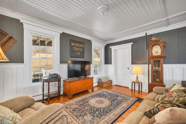959 Presidential Hwy, Jefferson, NH 03583 - living room with crown molding, healthy amount of natural light, wallpapered walls, wainscoting, and a baseboard radiator