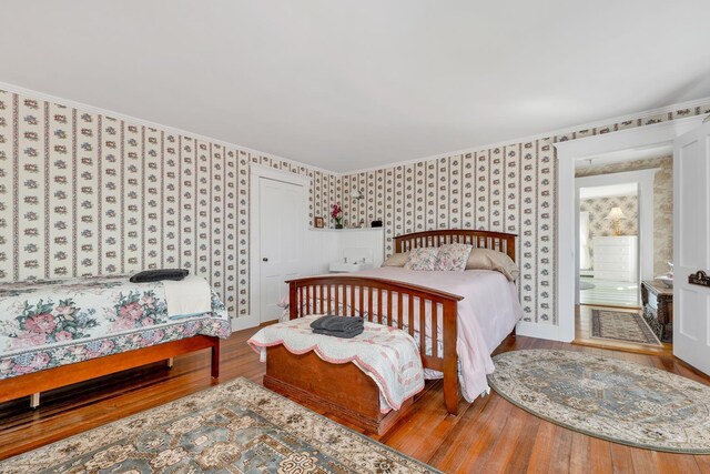959 Presidential Hwy, Jefferson, NH 03583 - bedroom with wallpapered walls, wood finished floors, ornamental molding, ensuite bath, and baseboards