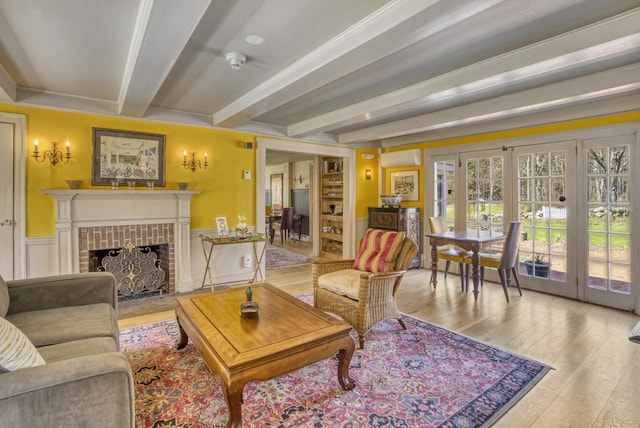 499 Andover Rd, New London, NH 03257 - living room featuring beamed ceiling, hardwood / wood-style floors, a fireplace, a wall mounted AC, and french doors