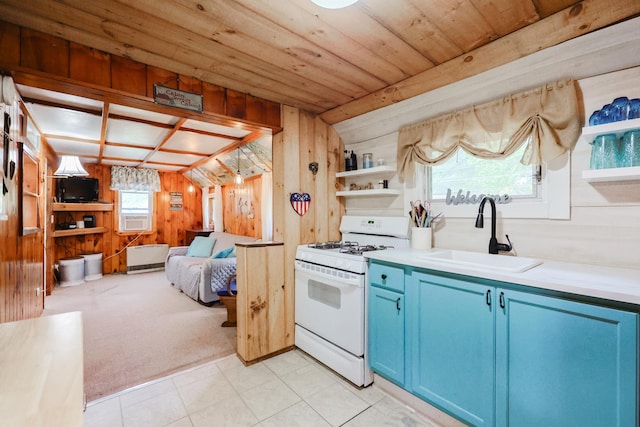 26 Neal Shore Rd, Meredith, NH 03253 - kitchen with white range with gas stovetop, blue cabinetry, a sink, wooden walls, and open shelves