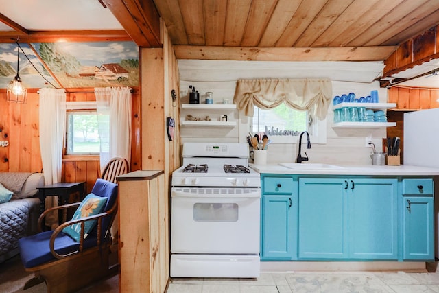 26 Neal Shore Rd, Meredith, NH 03253 - kitchen with white gas range oven, blue cabinetry, a sink, open shelves, and healthy amount of natural light