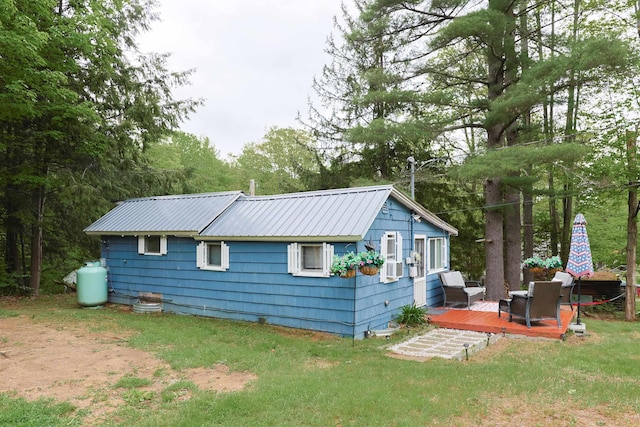 26 Neal Shore Rd, Meredith, NH 03253 - view of side of home with a wooden deck, metal roof, a lawn, and cooling unit