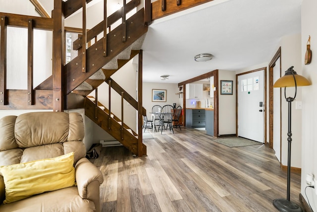 21 Pleasant Dr, Grantham, NH 03753 - living area featuring baseboard heating, wood finished floors, stairway, baseboards, and healthy amount of natural light