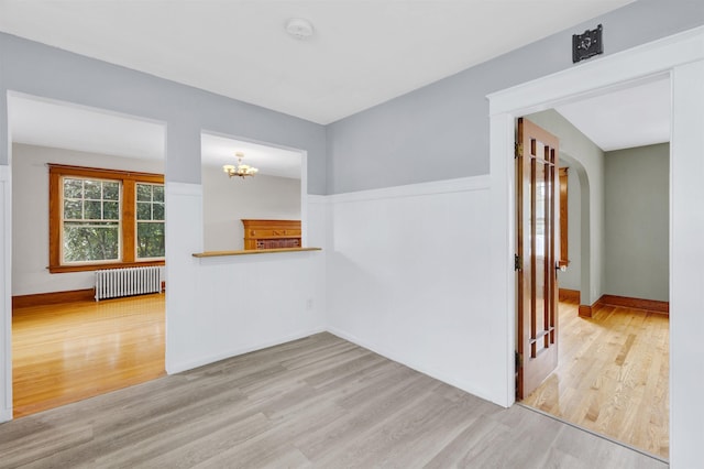 55 Washington St, Rochester, NH 03867 - spare room featuring radiator, wood finished floors, a smoke detector, and a chandelier