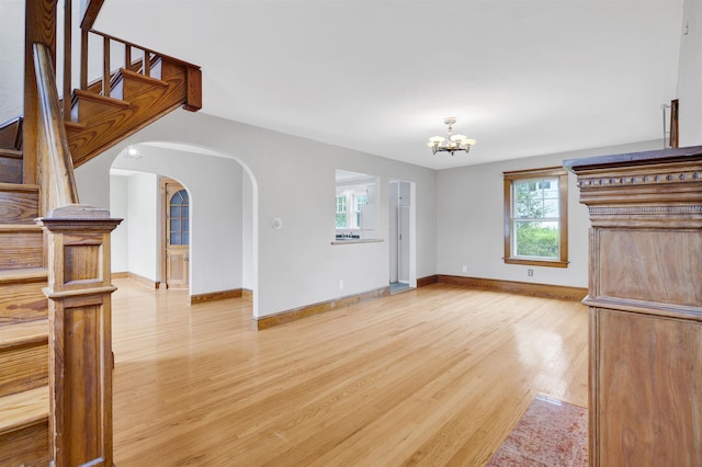 55 Washington St, Rochester, NH 03867 - unfurnished living room featuring healthy amount of natural light, light wood-style flooring, a chandelier, and baseboards