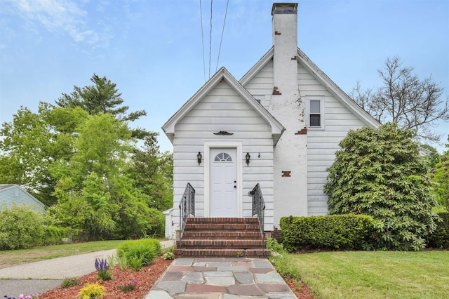 55 Washington St, Rochester, NH 03867 - view of front of property featuring a chimney, a front yard, and entry steps