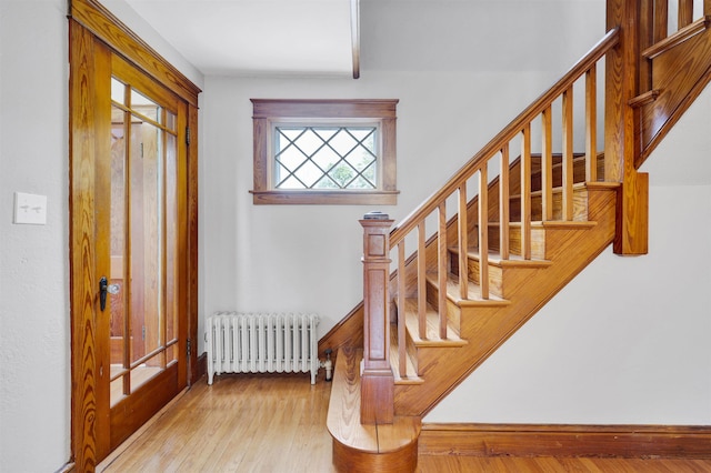 55 Washington St, Rochester, NH 03867 - foyer featuring radiator heating unit, wood-type flooring, stairs, and baseboards