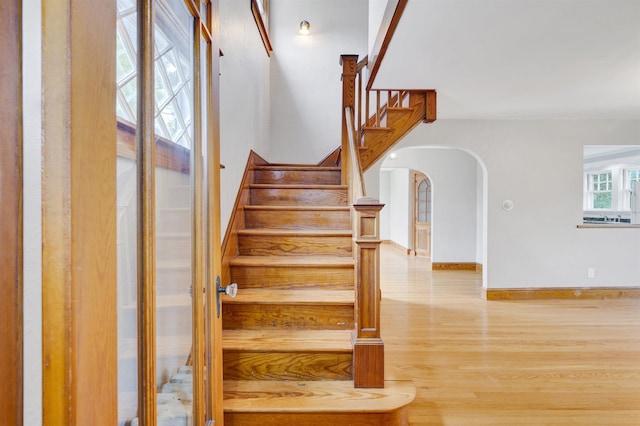 55 Washington St, Rochester, NH 03867 - staircase with arched walkways, wood finished floors, and baseboards
