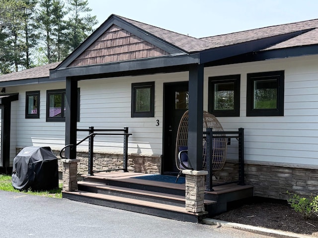 2366 Mountain Rd Unit 3, Stowe, VT 05672 - doorway to property featuring stone siding and roof with shingles