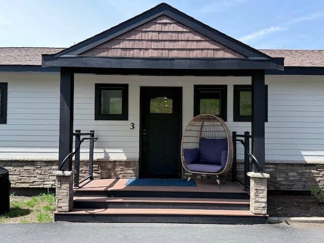 2366 Mountain Rd Unit 3, Stowe, VT 05672 - entrance to property with covered porch, stone siding, and roof with shingles