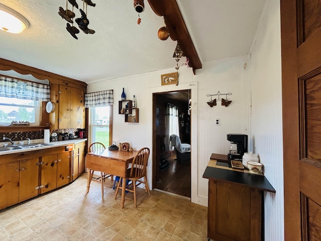 6998 River Rd, Lemington, VT 05903 - kitchen featuring a sink, brown cabinets, healthy amount of natural light, beamed ceiling, and crown molding
